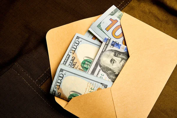 Kağıt bir zarfın içinde yüz dolarlık banknotlar. Zarfın içinde para almak. Siyah muhasebe. Rüşvet vermek..