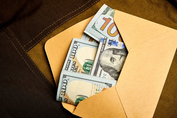 Kağıt bir zarfın içinde yüz dolarlık banknotlar. Zarfın içinde para almak. Siyah muhasebe. Rüşvet vermek..