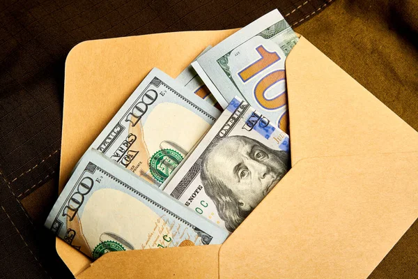 Kağıt bir zarfın içinde yüz dolarlık banknotlar. Zarfın içinde para almak. Siyah muhasebe. Rüşvet vermek..