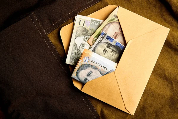 Kağıt bir zarfın içinde yüz dolarlık banknotlar. Zarfın içinde para almak. Siyah muhasebe. Rüşvet vermek..