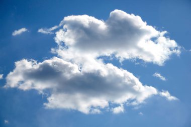 Mavi gökyüzünde beyaz kabarık bulutlar.