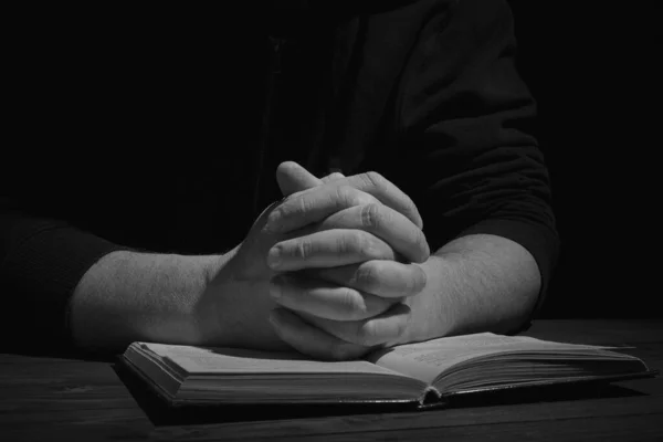 Duas Mãos Num Livro Homem Reza Escuro Bíblia — Fotografia de Stock