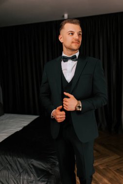 Man in a tuxedo prepares for a formal event in a stylish indoor setting