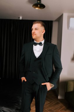 Stylish man in formal attire posing confidently indoors, showcasing modern elegance