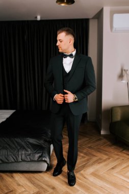 Stylish man in formal attire preparing for event indoors