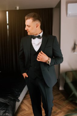 Stylish man in formal suit getting ready for a special event in a modern room