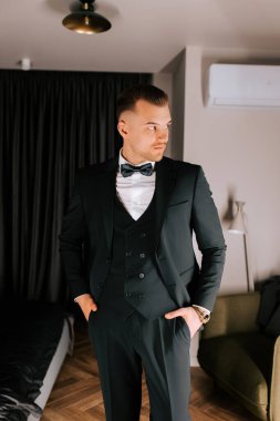 Stylish man in formal suit poses elegantly in modern indoor setting before an event