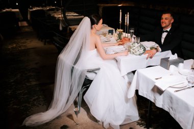 Elegant couple celebrating their wedding reception at an intimate restaurant setting