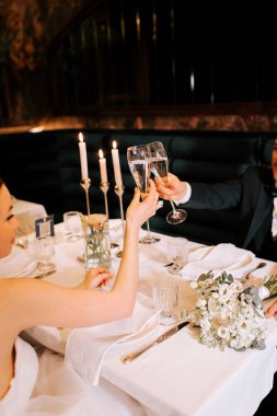 Couple celebrates special occasion with champagne toast at elegant dinner table