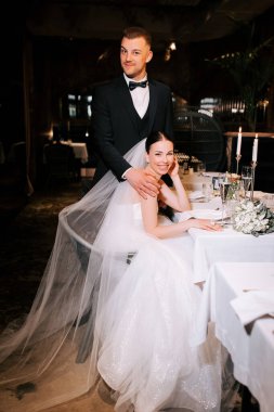 Couple celebrates wedding at elegant restaurant with romantic ambiance and stylish decor