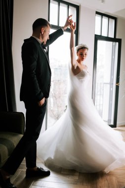 Couple elegantly dance together in a stylish indoor setting during their wedding day