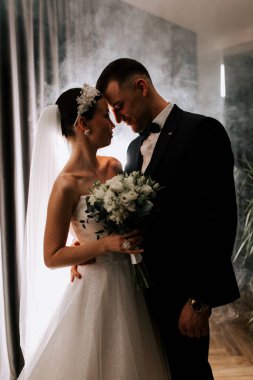 Couple shares a romantic moment while celebrating their wedding indoors with soft lighting
