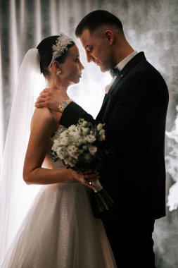 Romantic wedding couple sharing an intimate moment during their ceremony in elegant attire
