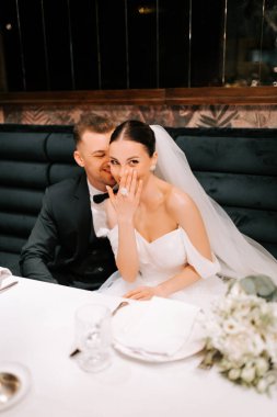 Joyful newlyweds share an intimate moment during their wedding reception dinner