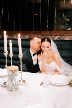 Couple enjoys intimate moment during candlelit wedding reception at elegant venue