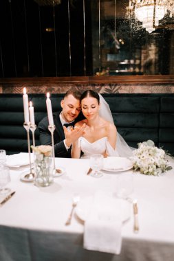 Couple enjoying a romantic moment at an elegant wedding reception in a cozy setting