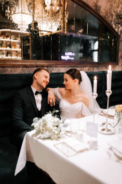 Couple enjoying a romantic dinner after their wedding ceremony in an elegant restaurant