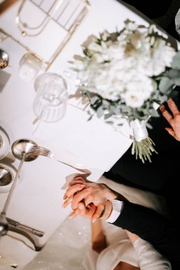 Couple holding hands at a beautifully set dining table during a special celebration