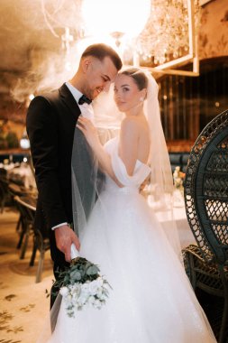 Couple shares romantic moment in elegant restaurant after wedding ceremony