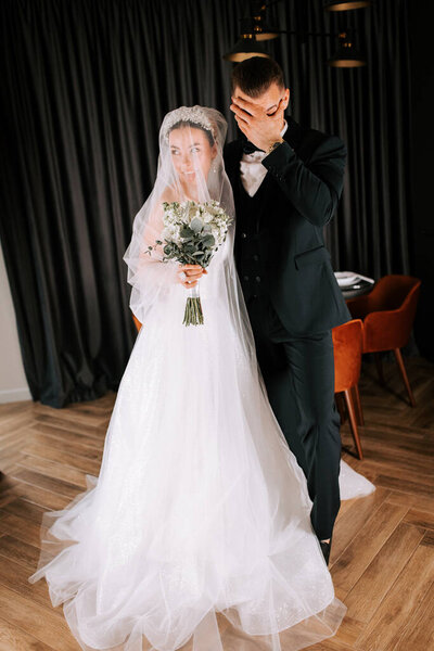 Couple shares joyful moment during wedding ceremony in elegant indoor setting