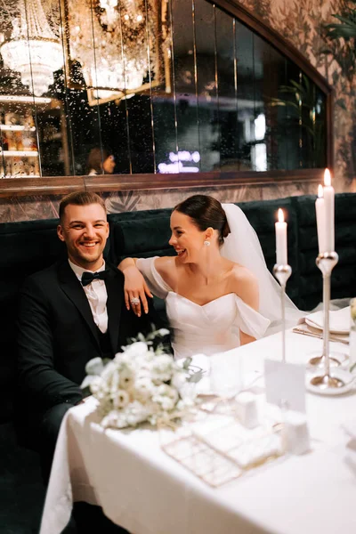 Couple celebrates their wedding in an elegant restaurant setting at night