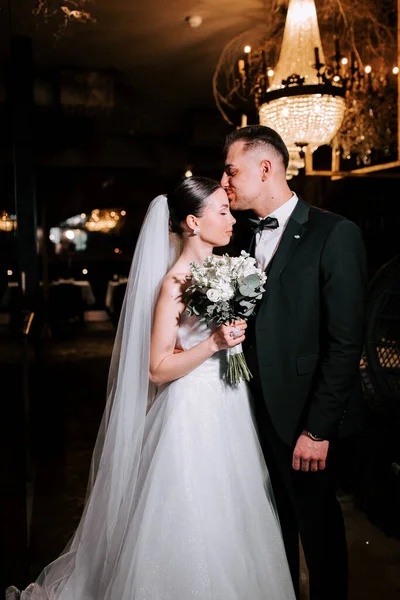 Newlywed couple sharing a tender moment during an elegant wedding celebration in a venue