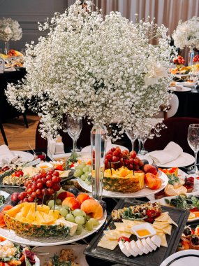 Müsrif bir yemek ortamında, şenlikli bir etkinlikte zarif meyve ve çiçek gösterisi.