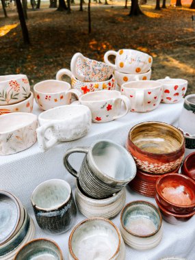 Seramik kupalar ve kaseler sonbaharda bir parktaki bir zanaatkar pazarında sergilendi.