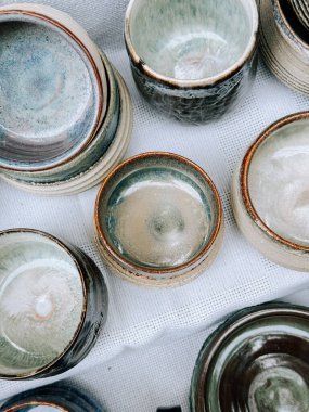 Öğleden sonra ışığı altında yerel bir zanaatkar pazarında sergilenen eşsiz çömlek koleksiyonu