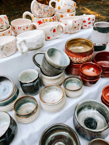 Yerel bir pazarda çeşitli stil ve renklerin sergilendiği el yapımı çömlek.
