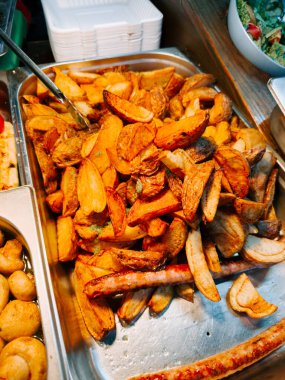 Akşam boyunca markette servis edilen lezzetli baharatlı kızarmış patatesler.