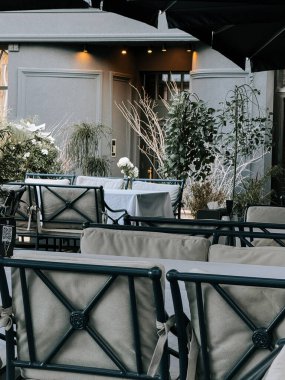 Öğleden sonra güneşli bir kafede şık dekorlu açık hava oturma odası.