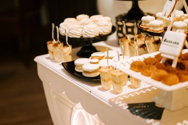 Bir kutlama etkinliğinde çeşitli hamur işleri ve şekerlerin yer aldığı zarif bir tatlı gösterisi.