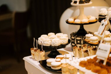 Zarif bir ortamda bir kutlama etkinliğinde çeşitli ikramlar sunan tatlı masası