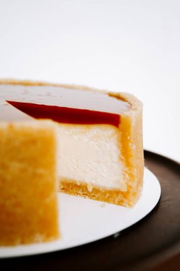 Ahşap bir masada kırmızı meyveli nefis bir cheesecake.