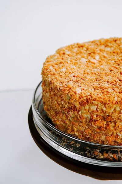 Cam servis tabağında gevrek bademlerle kaplı nefis katmanlı pasta.