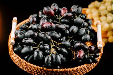 Taze olgun üzümler dokuma sepetine dizildi. Keyif almaya ya da aşçılık kullanımına hazır.