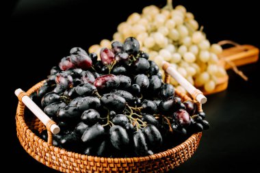 Tüketim ve keyif için dokuma sepetine yerleştirilmiş olgun üzümler.