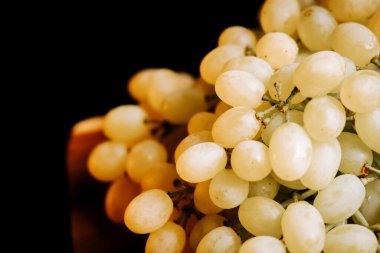 Hasat mevsiminde kırsal bir ortamda olgun beyaz üzümlerin tadını çıkarıyorum.