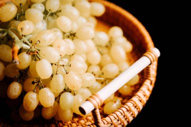 Dokuma sepetinde taze üzümler. Mutfak ortamında hasat veya tüketime hazır.