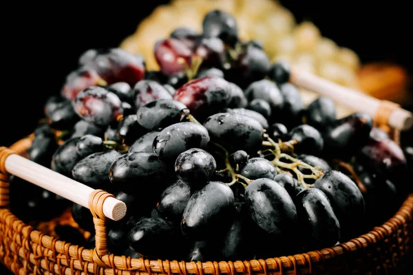 Taze üzümler dokuma sepetinde sergileniyor. Hasat ve keyif için hazır.