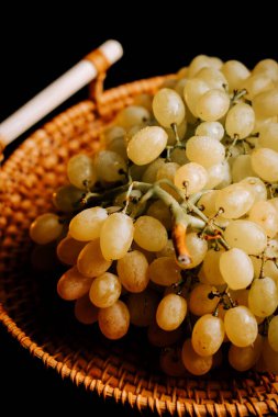 Taze üzümler dokunmuş sepetin içinde sergileniyor yaz tatiline hazır.