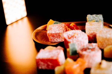 Türk Lokum 'u canlı renklerle ahşap bir tabağa dizilmiş ve şekerle tozlanmış