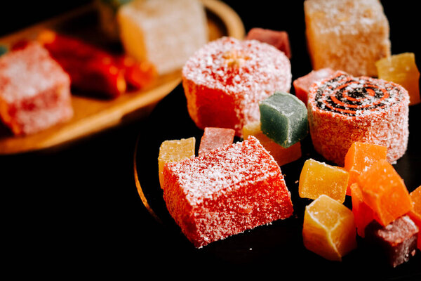 Exotic Turkish delights lokum arranged artfully on a dark platter ready for tasting