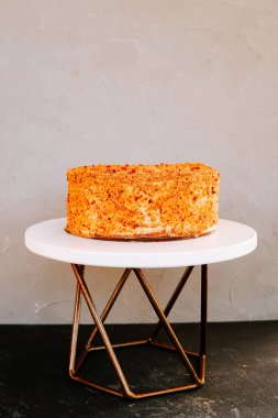 Modern bir stantta parlak bir şekilde sergilenen çok güzel hazırlanmış bir pasta.