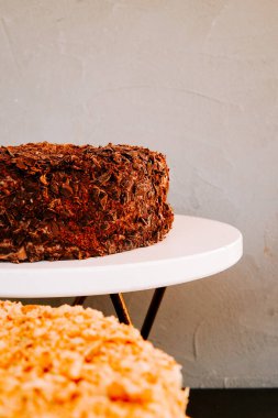 Modern bir ortamda beyaz pasta standında sergilenen lezzetli çikolatalı pasta.