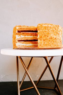 Öğleden sonra sıcak mutfak ortamında beyaz standın üzerinde nefis katmanlı pasta.