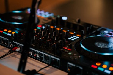 DJ equipment setup with colorful lights in a modern music venue at night