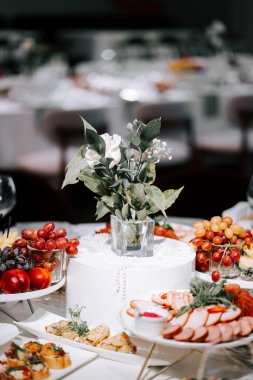 Elegant dining table display featuring gourmet food and fresh flowers in a festive setting