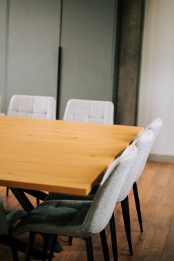 Verimli toplantılar için ahşap masa ve gri sandalyeli modern konferans odası.